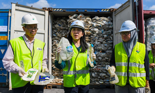 Bộ trưởng Yeo Bee Yin (giữa) đứng trước các container chứa rác thải nhựa tại cảng Klang hôm nay. Ảnh: AFP.