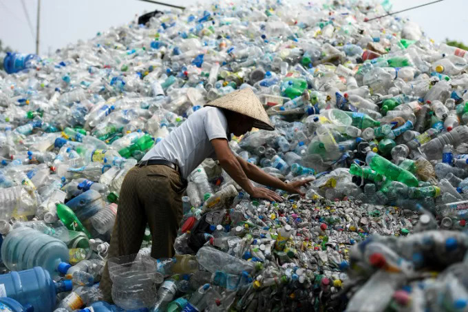 Người đàn ông nhặt chai nhựa đã qua sử dụng tại một bãi rác ở Hà Nội, tháng 6/2018. Ảnh: AFP/Nhac Nguyen.