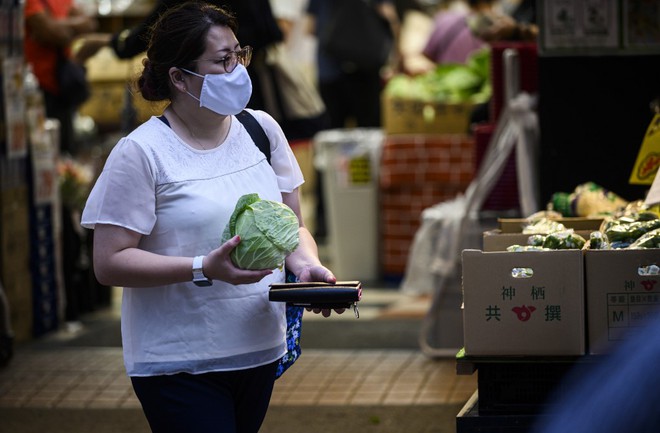 Một khách hàng cầm bắp cải về nhà sau khi siêu thị tính tiền đối với túi ni lông /// AFP